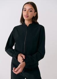 Black zip-up travel jacket with ribbed cuffs and mock neck collar, front on-model view