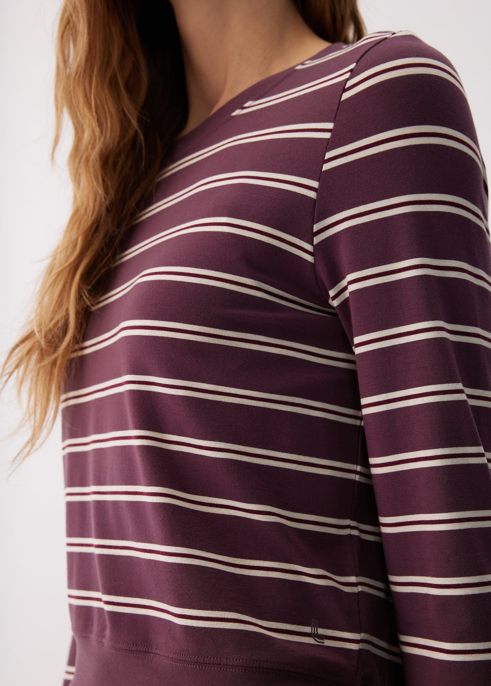 Women's long sleeve striped top in dark purple with cream horizontal stripes, close-up detail view