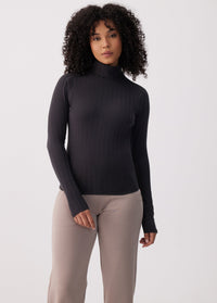 Women's ribbed turtleneck long-sleeve top in black, fitted silhouette, front view on model