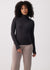 Women's ribbed turtleneck long-sleeve top in black, fitted silhouette, front view on model