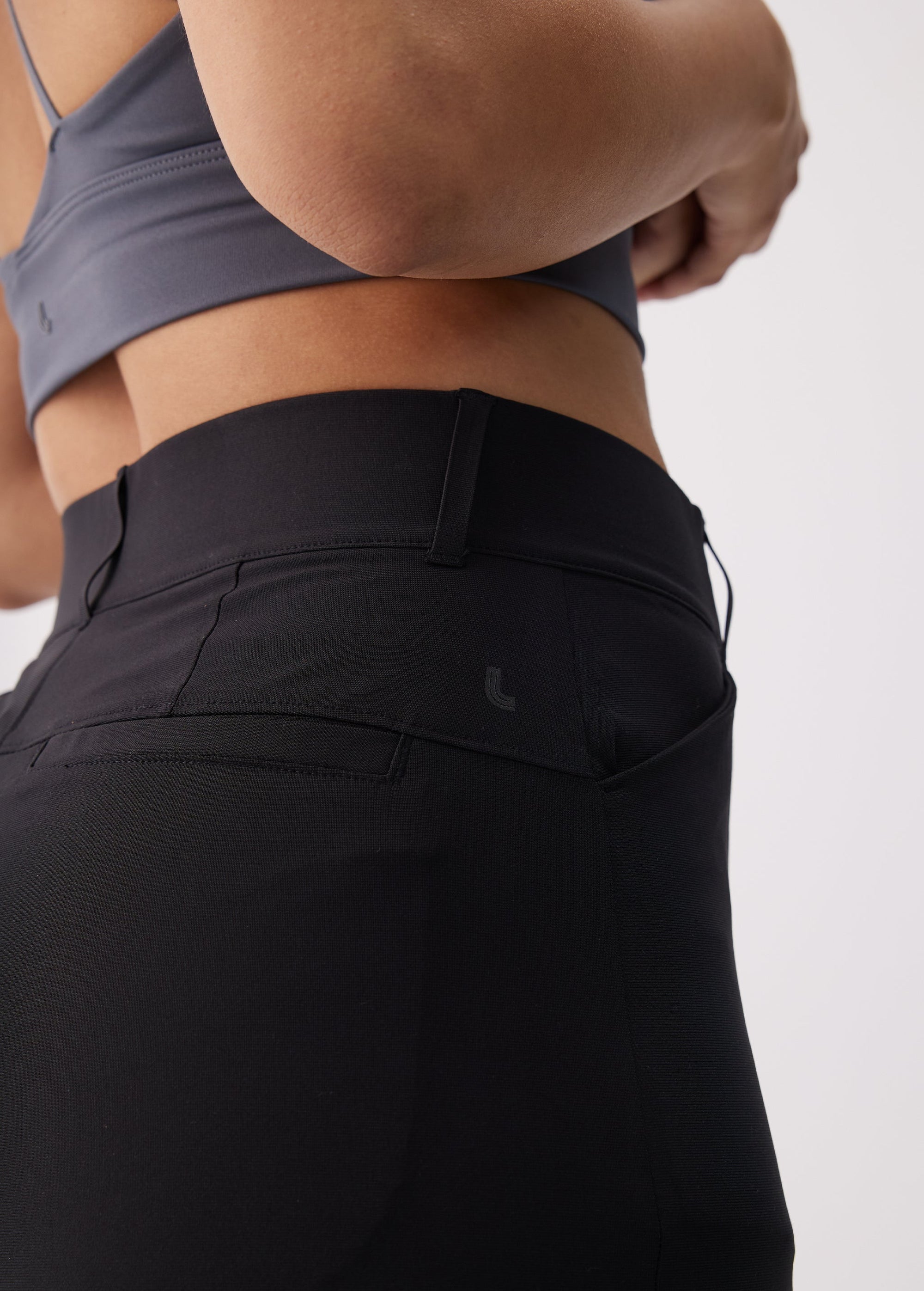 Close-up back view of black travel trousers showing rear pockets and waistband detail
