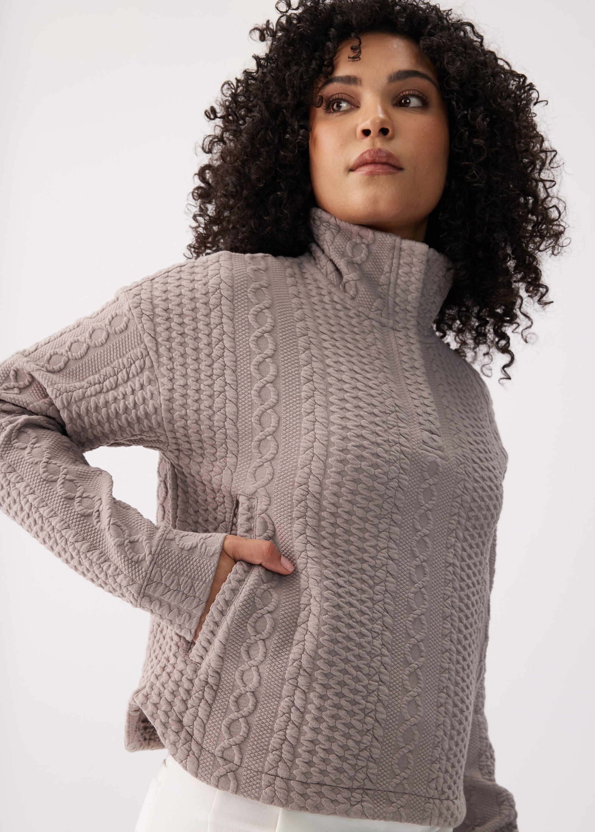 Women's cable-knit textured mock-neck long sleeve pullover top, three-quarter front view on model