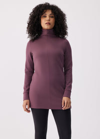 Women's long-sleeve turtleneck tunic top with seam detail, front view on model