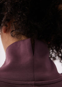 Close-up back neck detail of a long-sleeve turtleneck tunic with center seam