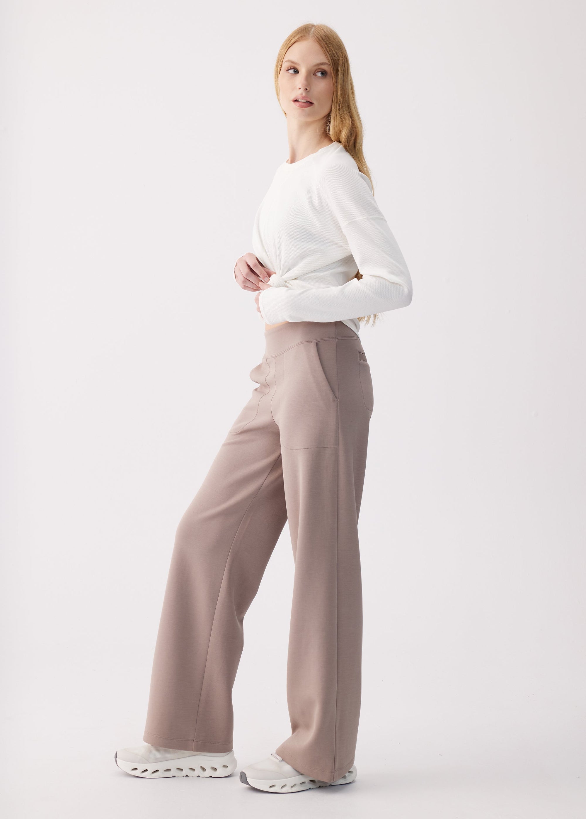 Wide-leg high-waist pants in taupe, side view on model with white long-sleeve top