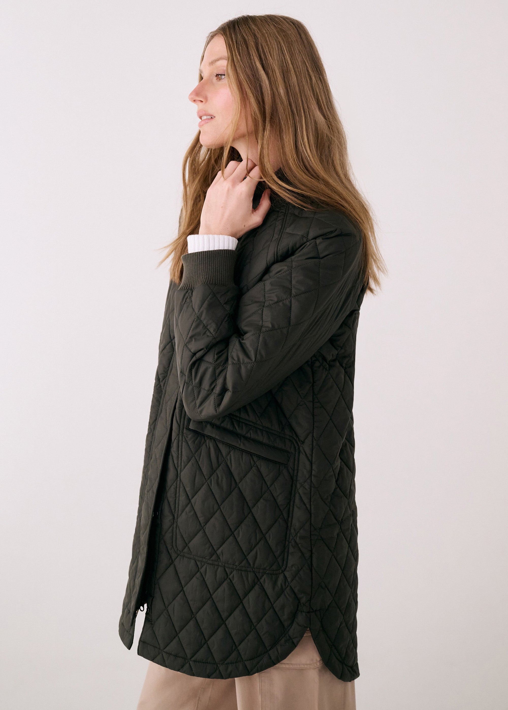 Women's quilted 3/4 length bomber jacket in dark olive, side view on model