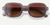 Square-shaped sunglasses with translucent gray frame and brown gradient lenses on white background