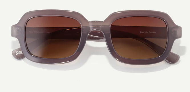 Square-shaped sunglasses with translucent gray frame and brown gradient lenses on white background