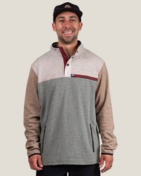 Men's color-block fleece pullover with snap collar, chest logo patch, and zip pockets, front view