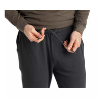 Close-up detail of men's jogger waistband with drawstring being adjusted by both hands