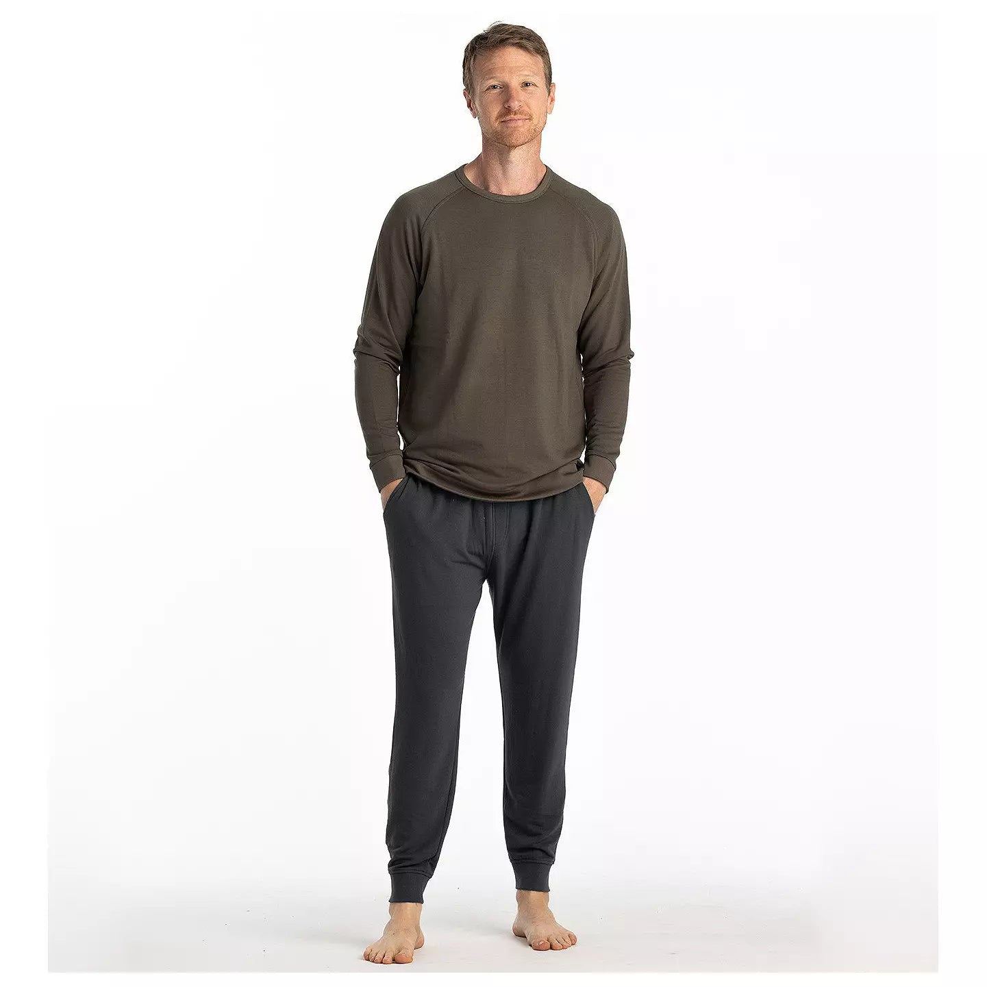 Man wearing dark charcoal lightweight fleece jogger pants with ribbed cuffs and elastic waistband, full front view