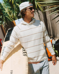 Man carrying a surfboard wearing a white striped pullover hoodie with kangaroo pocket