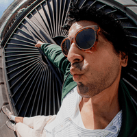 Oversized round tortoiseshell sunglasses with dark mirrored lenses worn on model, close-up side angle