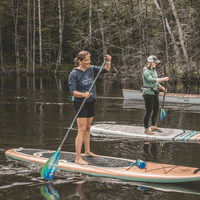 Two-piece fiberglass stand-up paddle with colorful teal and orange blade being used on lake