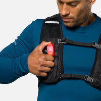 Red LED safety light clipped to black vest strap, compact rectangular design