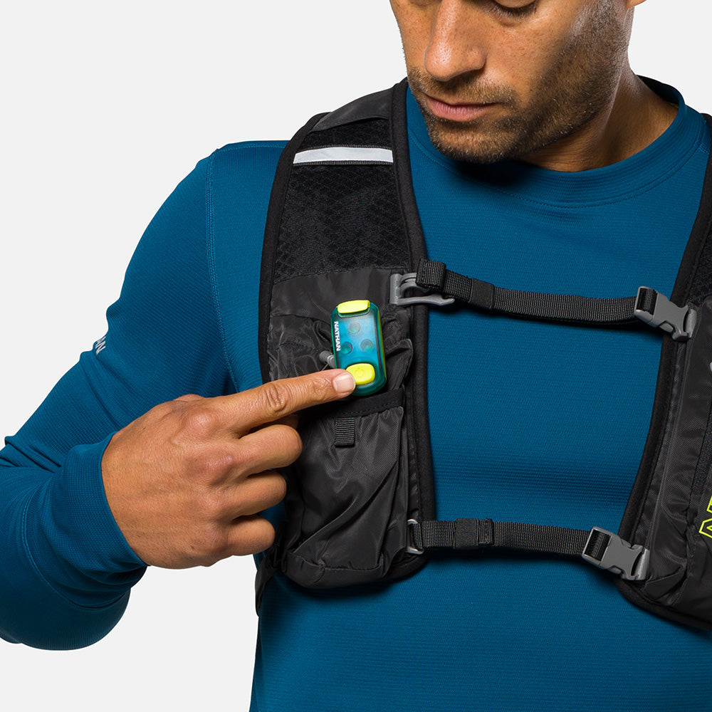 LED safety light clipped to chest pocket of running vest worn by person