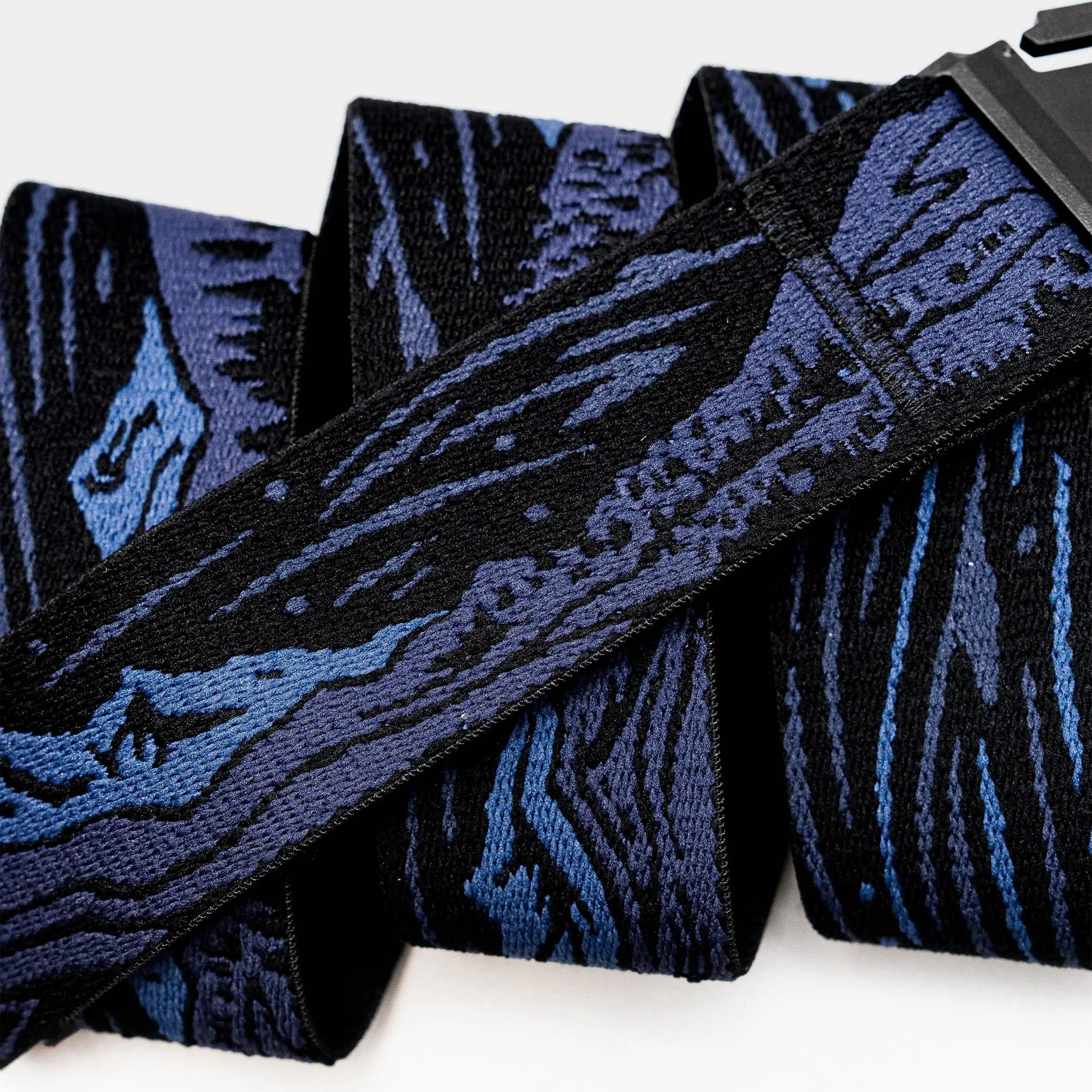Woven webbing belt with geometric pattern in navy and black colors, displayed flat