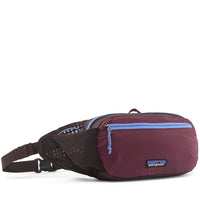 Hip pack fanny bag in dark plum with light blue zipper, mesh side panel, and adjustable strap