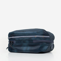 Dark teal packing cube with dual zippers and grey webbing, bottom angle view