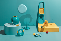 Beach toy set with bucket, scoops, and strainers in teal and yellow colors on studio background