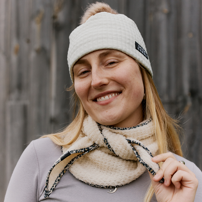 Cream sherpa fleece scarflette with leopard print trim, worn around neck on model
