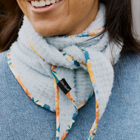 Fleece scarflette with colorful floral-print trim tied around neck, on-model lifestyle shot