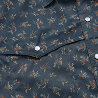 Close-up of dark blue shirt with small floral print showing snap buttons and chest pocket details