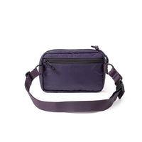 Purple crossbody bag with adjustable strap and front zip pocket on white background