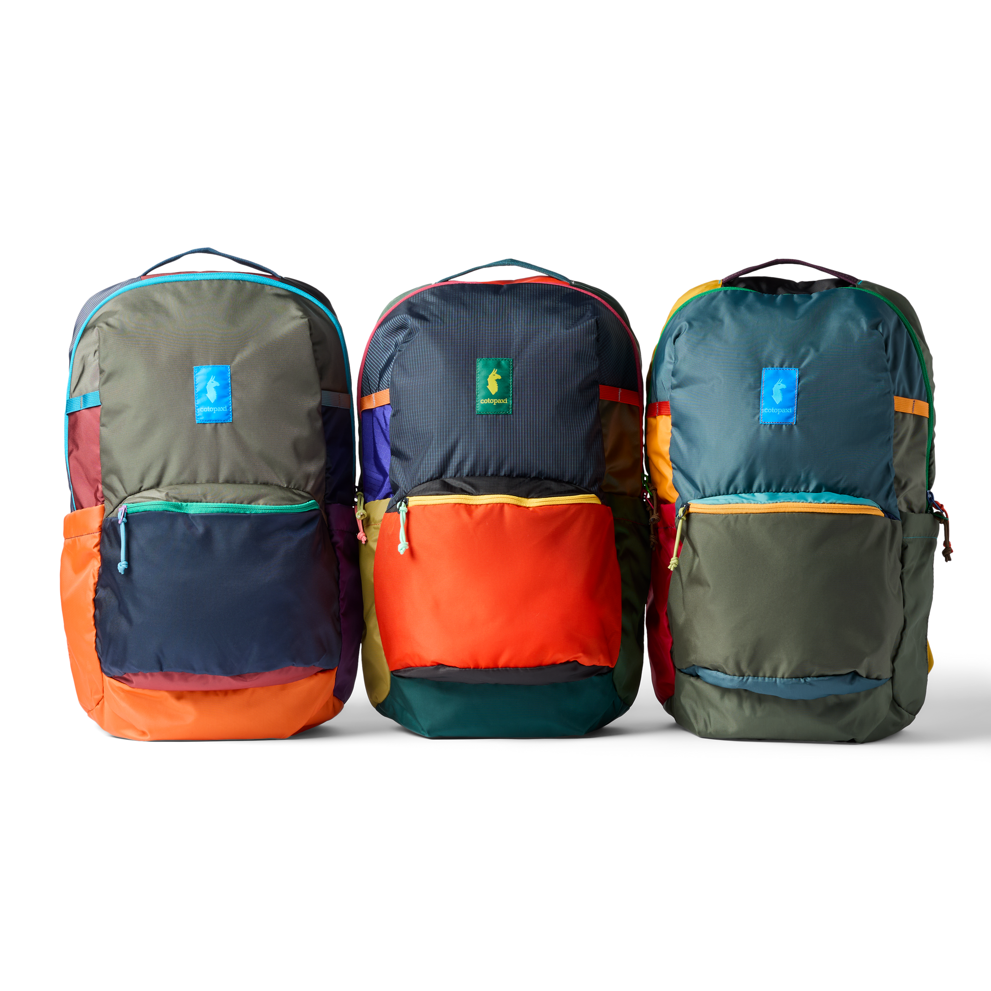 Three colorblock backpacks with front zip pockets and carry handles, shown in group shot