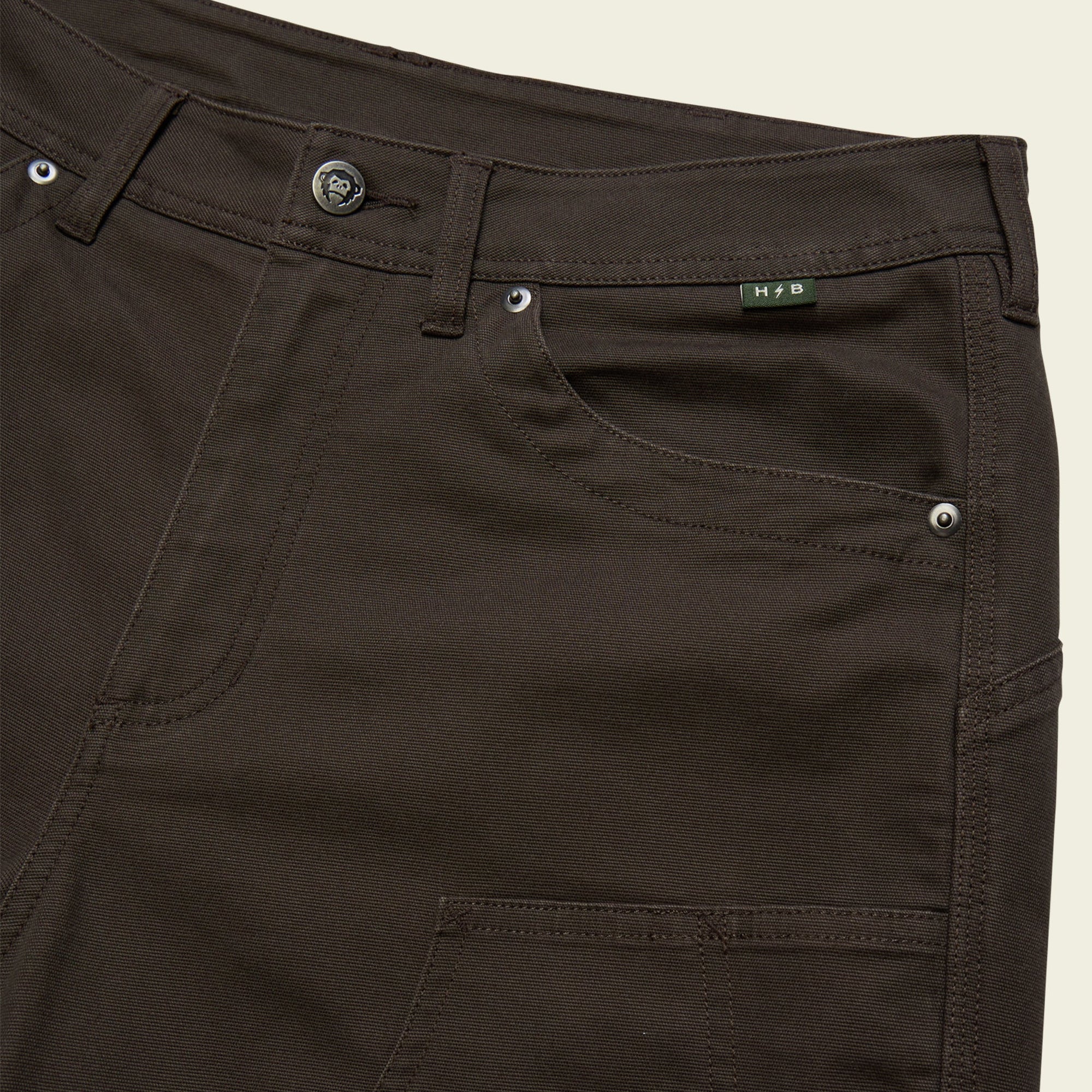 Dark olive shorts detail showing waistband, front pocket, and stitching construction