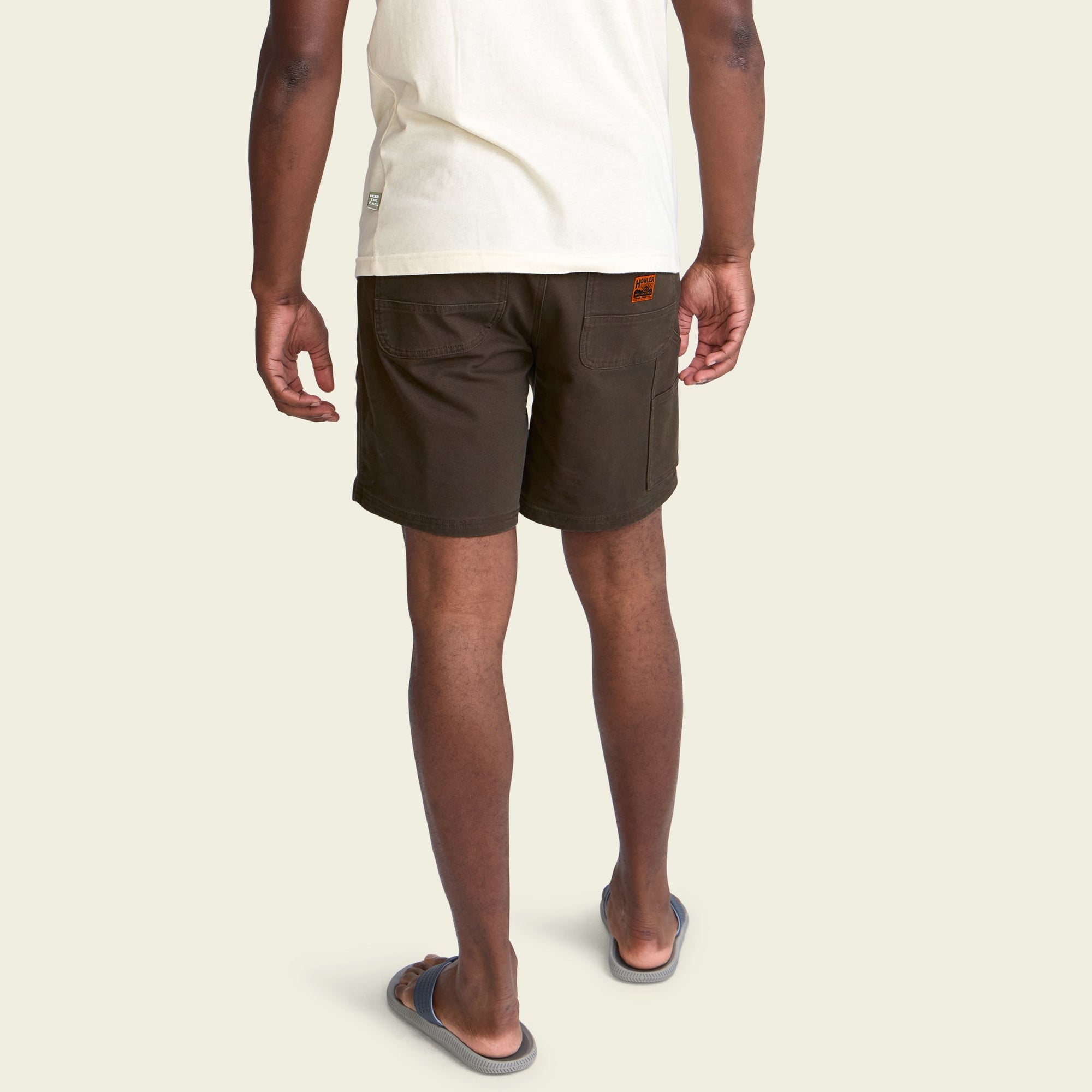 Dark olive cargo shorts with back pockets, rear view on model