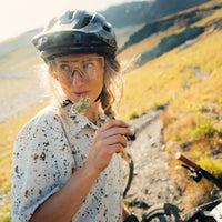 Woman wearing speckled print short sleeve sun shirt while mountain biking outdoors
