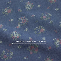 Close-up detail of blue chambray fabric with scattered small floral bouquet print pattern