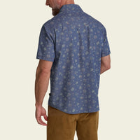 Men's short-sleeve floral print button-up shirt in washed indigo, back view on model