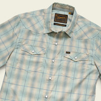 Men's short-sleeve western snap shirt in light seafoam plaid, angled flat-lay view showing chest pockets