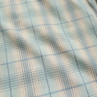 Close-up detail of plaid woven fabric with seafoam, beige, and blue tones and decorative stitching