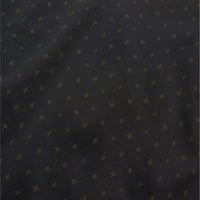 Dark shirt fabric with small golden star pattern scattered across surface