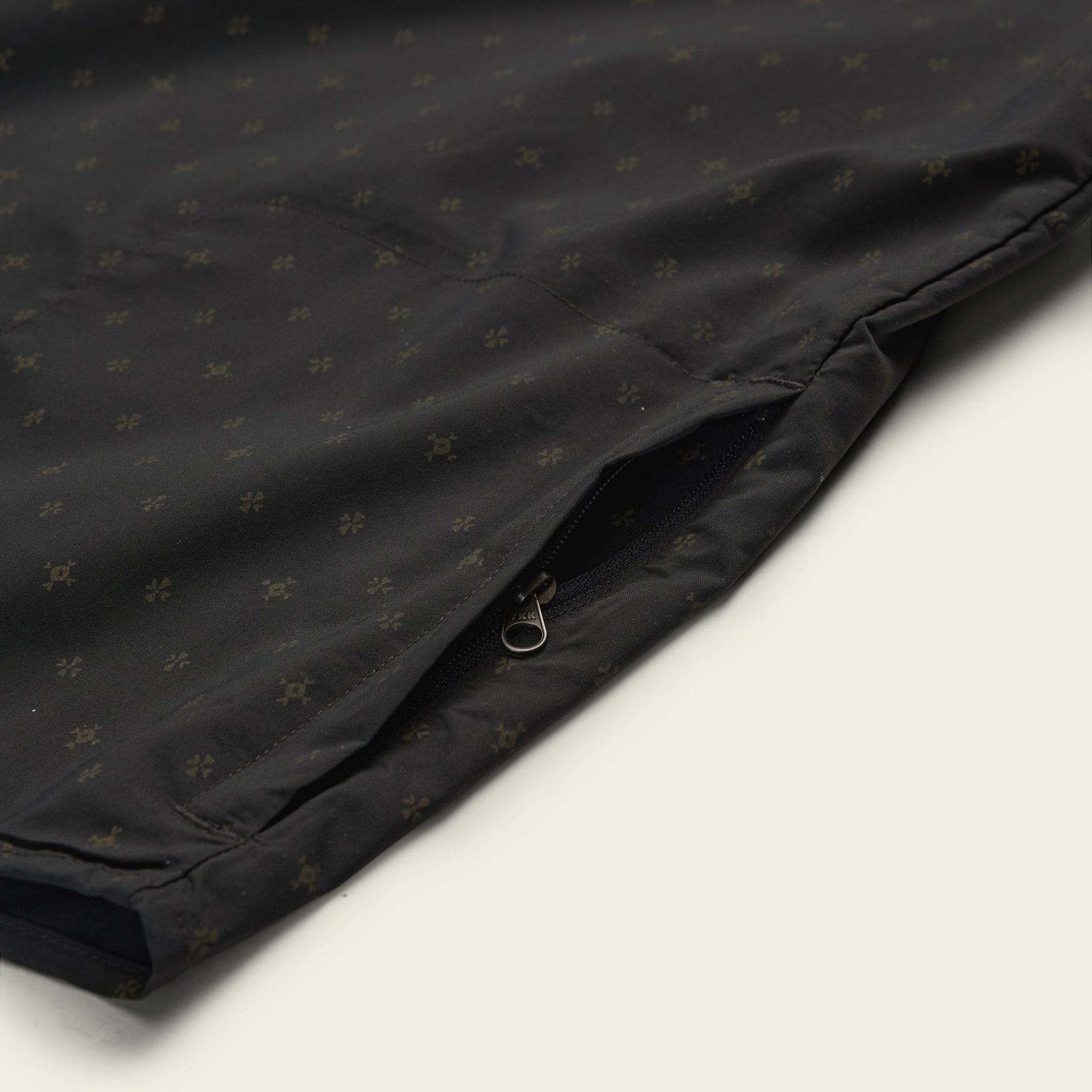 Black button-up shirt with small star pattern, detail view showing chest pocket with zipper