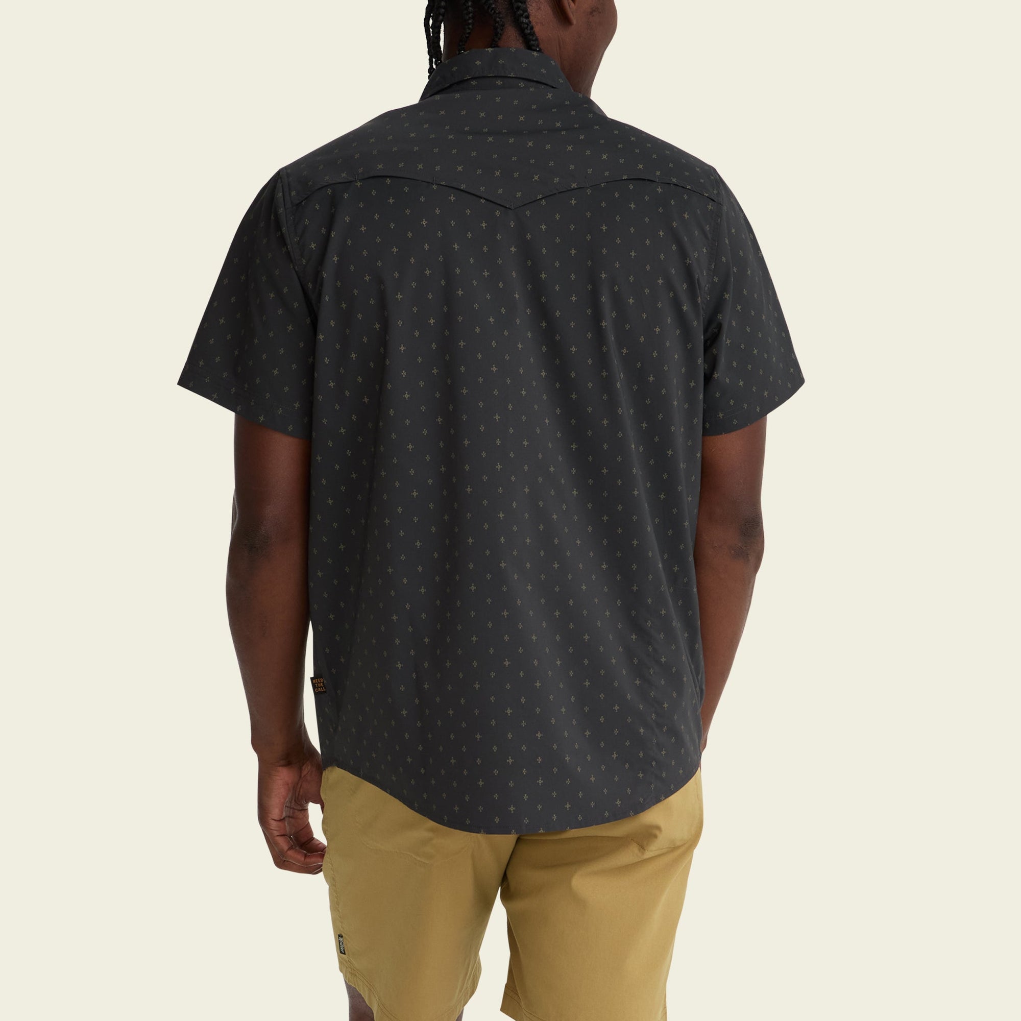 Dark patterned short-sleeve button-up shirt with star print, back view on model
