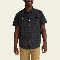 Dark patterned short-sleeve button-up shirt with chest pockets on male model
