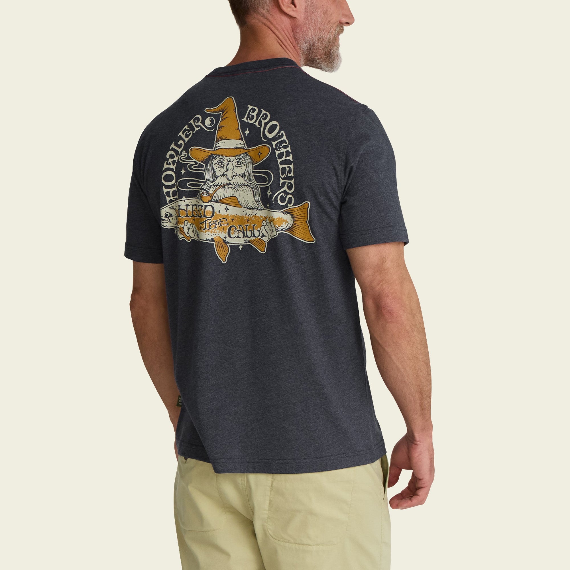 Dark heather t-shirt with wizard and fish graphic design, shown from back view on model