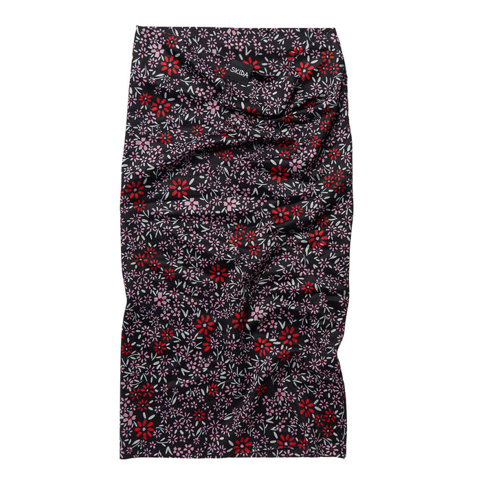 Floral patterned neck gaiter laid flat, black with red and pink flowers, tube style
