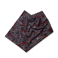 Floral print neck warmer gaiter folded flat, dark background with small red and pink flowers