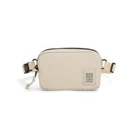 Cream colored ripstop belt bag with adjustable webbing strap and front logo patch