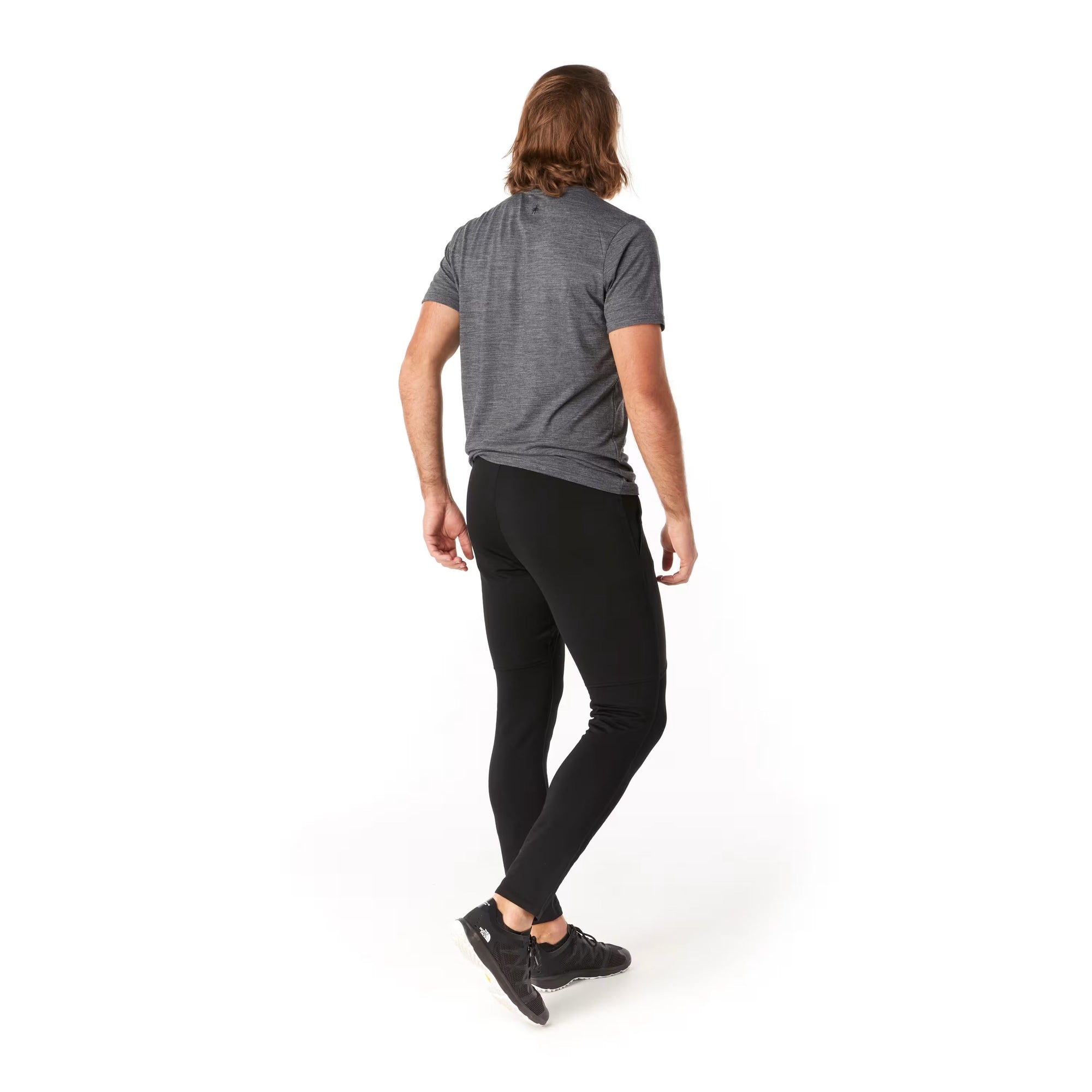 Men's black slim-fit active wind pants shown from back on male model with gray tee