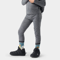 Kids' merino wool base layer leggings in heathered gray, shown on model with winter boots