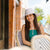 Wide brim sun hat in light beige with chin strap, worn by woman at outdoor café