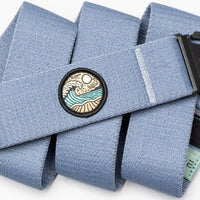 Light blue fabric belt with embroidered circular patch showing waves and landscape design