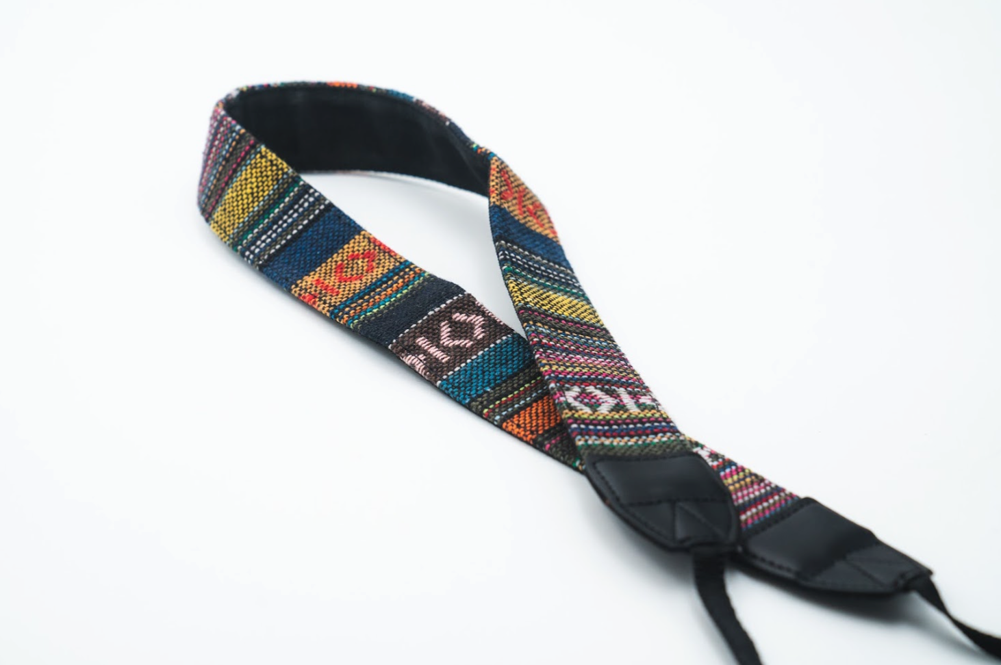 Multicolor woven tapestry camera strap with ethnic geometric pattern and black leather hardware ends