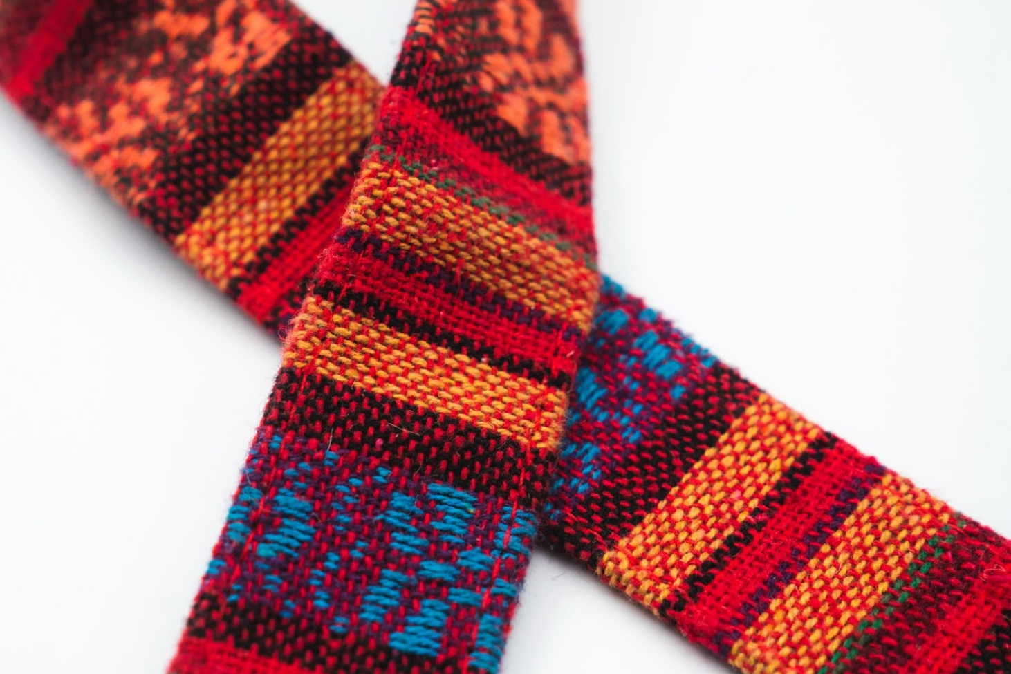 Close-up detail of a woven tapestry strap with bold multicolor stripes and geometric patterns